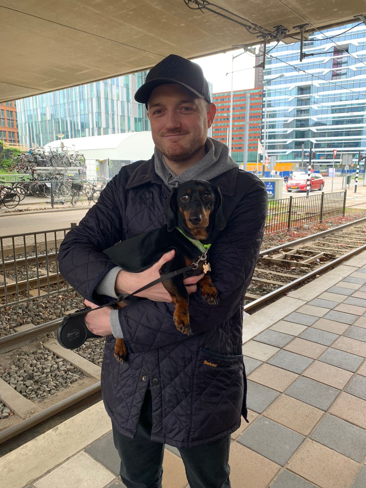 Man holding dog at train station